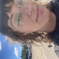 Image of Heather outside on a sunny day with her glasses and baseball cap on