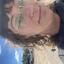 Image of Heather outside on a sunny day with her glasses and baseball cap on