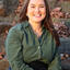 person with long brown hair and green long sleeve shirt